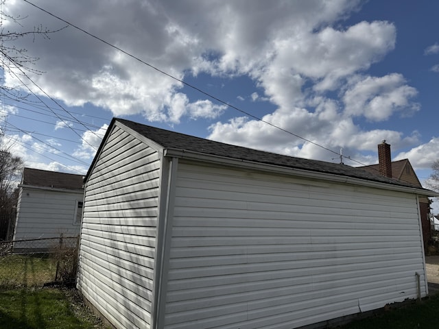 view of side of property with fence and a chimney