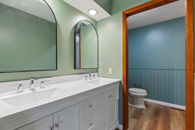4675 Treat Hwy, Adrian, MI 49221 - bathroom with wainscoting, toilet, double vanity, and wood finished floors