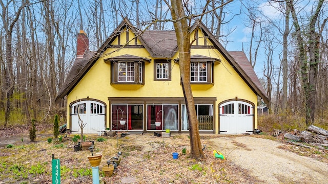 view of front of house with a chimney and stucco siding