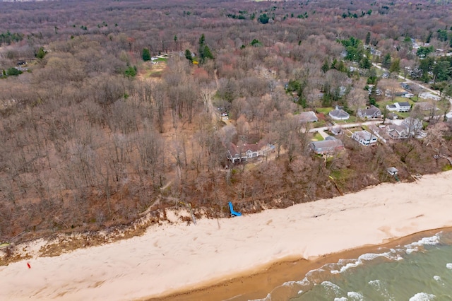 drone / aerial view with a wooded view and a water view