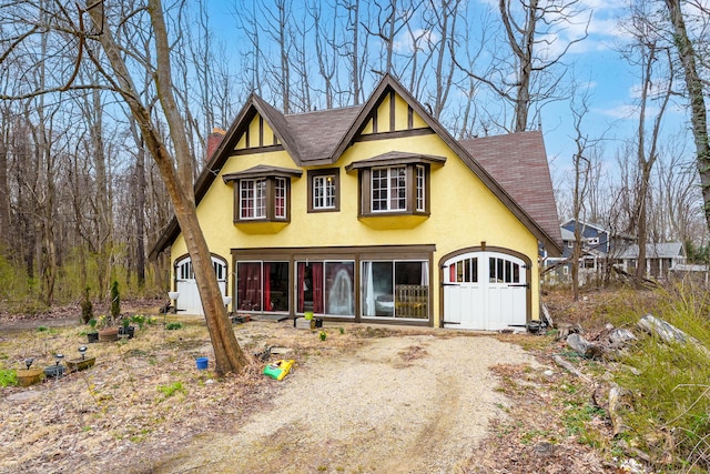 view of front of home featuring a chimney, a shingled roof, and stucco siding