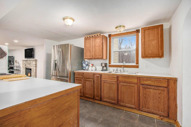 5353 Plum St, Coloma, MI 49038 - kitchen featuring stainless steel fridge with ice dispenser, brown cabinetry, a fireplace, and light countertops