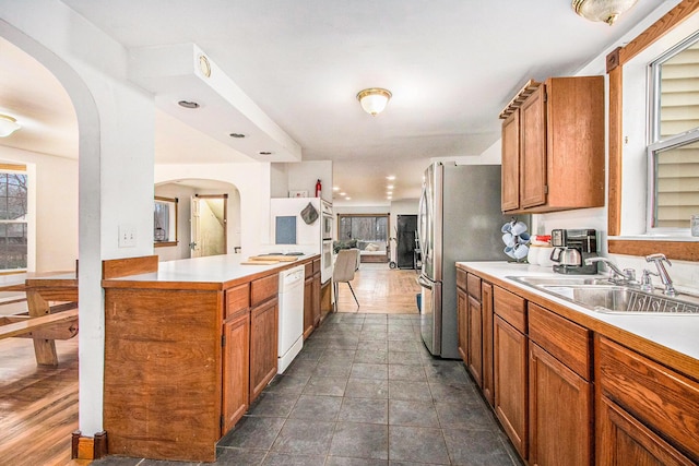 5353 Plum St, Coloma, MI 49038 - kitchen with arched walkways, light countertops, brown cabinetry, and healthy amount of natural light