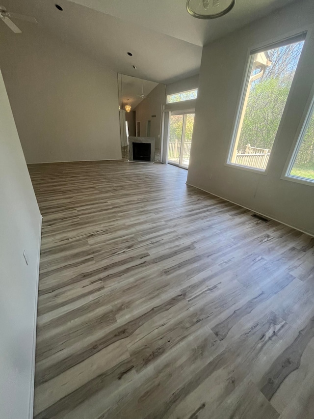 unfurnished living room with vaulted ceiling and wood finished floors