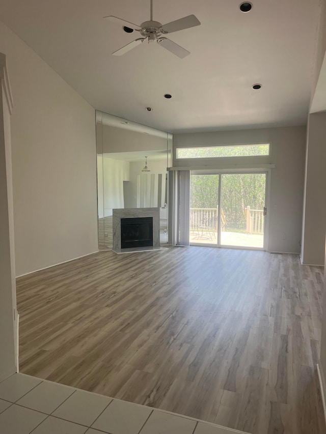 unfurnished living room with a ceiling fan, recessed lighting, wood finished floors, and a fireplace