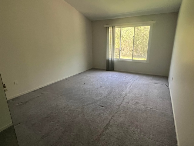 carpeted spare room with baseboards