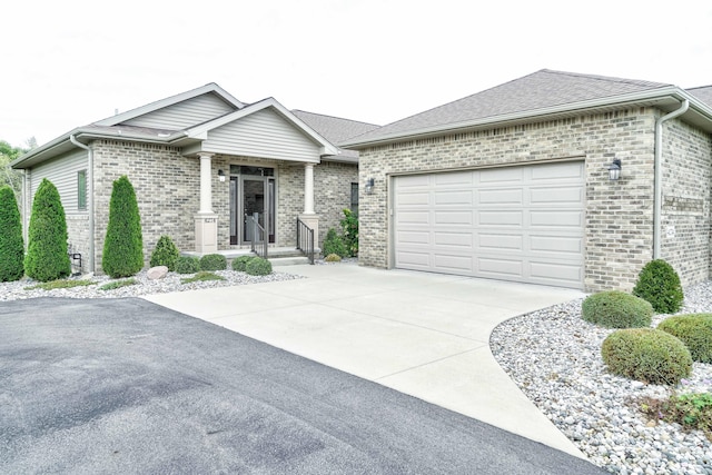 view of front of property with a garage, roof with shingles, brick siding, and driveway