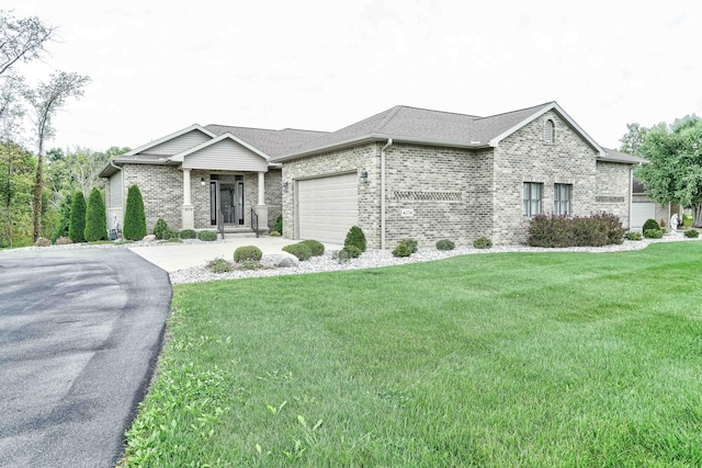 view of front facade with driveway, a garage, a front lawn, and brick siding