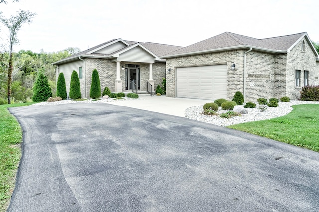 view of front of property featuring brick siding, a garage, and driveway