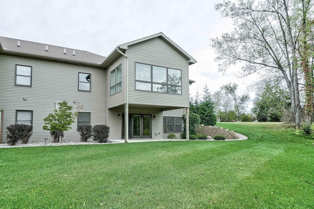 back of house with french doors and a lawn