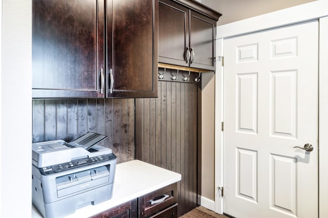 washroom with cabinet space and wood walls