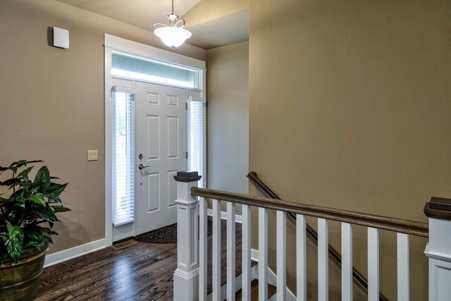 entryway with dark wood-style floors and baseboards