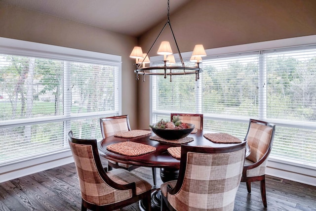 dining room with vaulted ceiling, an inviting chandelier, and wood finished floors