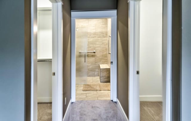 hallway featuring baseboards and carpet floors