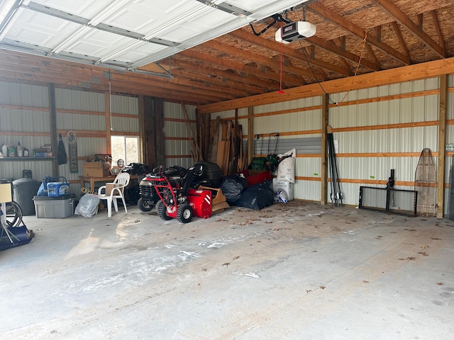 garage with a garage door opener and metal wall