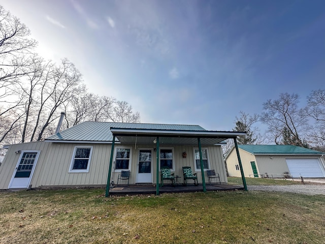 view of front facade featuring board and batten siding, metal roof, covered porch, and a front yard