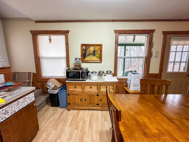 interior space featuring stainless steel microwave, butcher block countertops, light wood-type flooring, and brown cabinetry