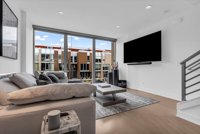 living area with floor to ceiling windows, recessed lighting, baseboards, and wood finished floors