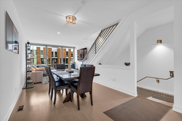 dining space featuring wood finished floors, baseboards, and visible vents