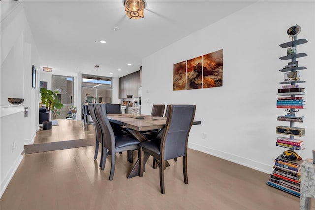dining space featuring recessed lighting, baseboards, and wood finished floors