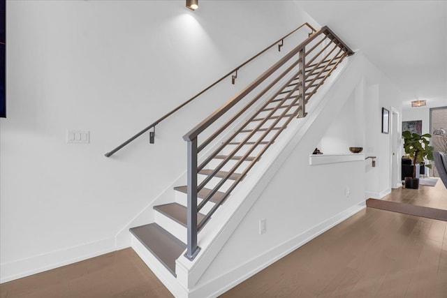 stairway with baseboards and wood finished floors