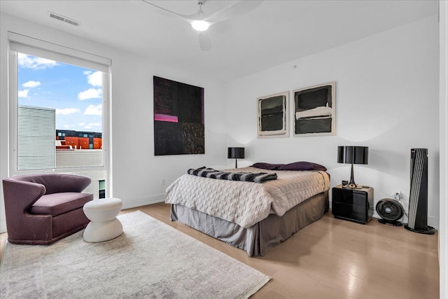 bedroom with wood finished floors, baseboards, a ceiling fan, and visible vents