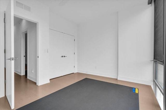 empty room with wood finished floors, baseboards, and visible vents