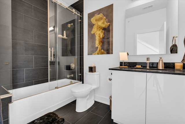 full bath featuring vanity, tile patterned flooring, toilet, visible vents, and bath / shower combo with glass door