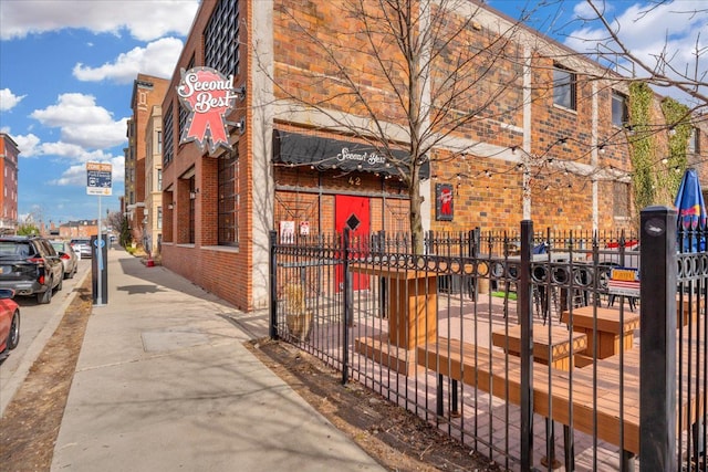 exterior space featuring brick siding and a fenced front yard