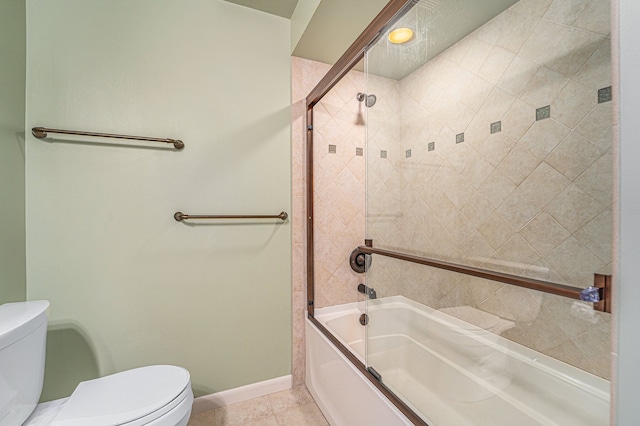 bathroom with baseboards, tile patterned flooring, toilet, and shower / bath combination with glass door