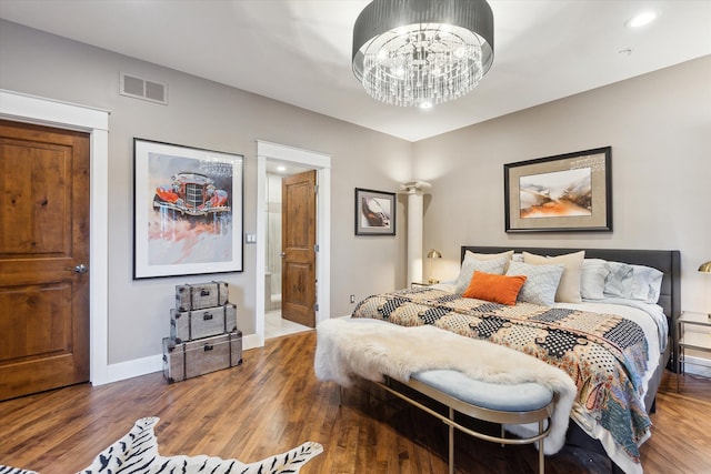 bedroom featuring wood finished floors, baseboards, a chandelier, ensuite bath, and recessed lighting