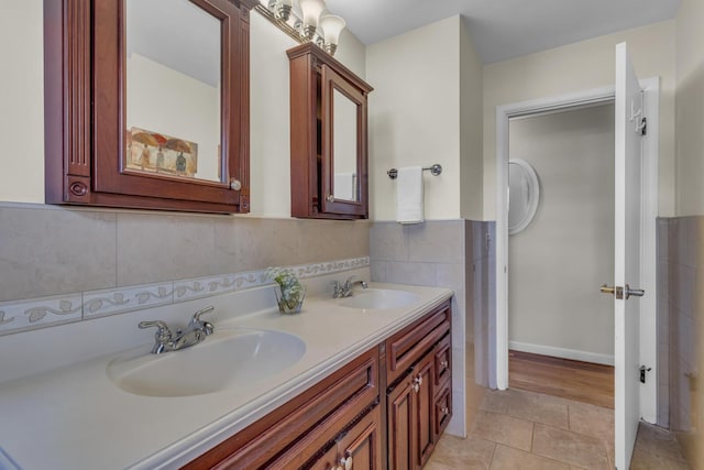 bathroom with a sink, tile patterned floors, tile walls, and double vanity