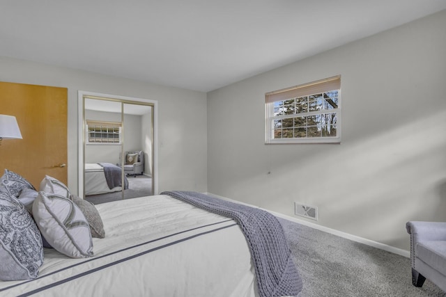 carpeted bedroom featuring a closet, baseboards, multiple windows, and visible vents