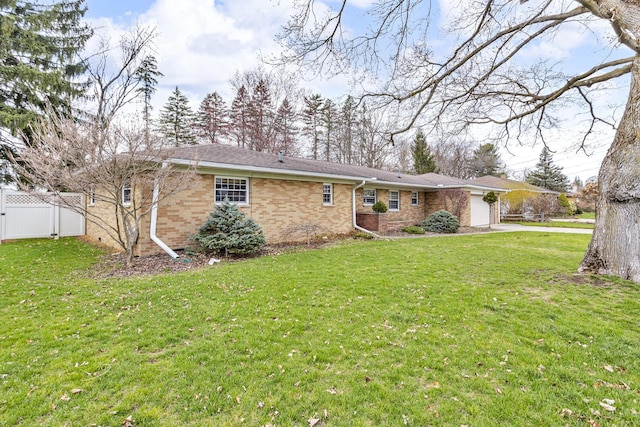 exterior space featuring brick siding, a front lawn, fence, and an attached garage