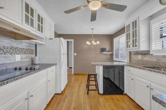 kitchen with white cabinets, ceiling fan with notable chandelier, black appliances, and a healthy amount of sunlight
