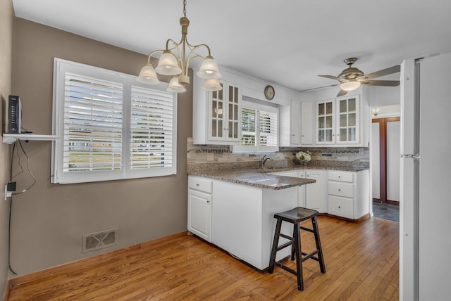 kitchen featuring white cabinetry, visible vents, and freestanding refrigerator