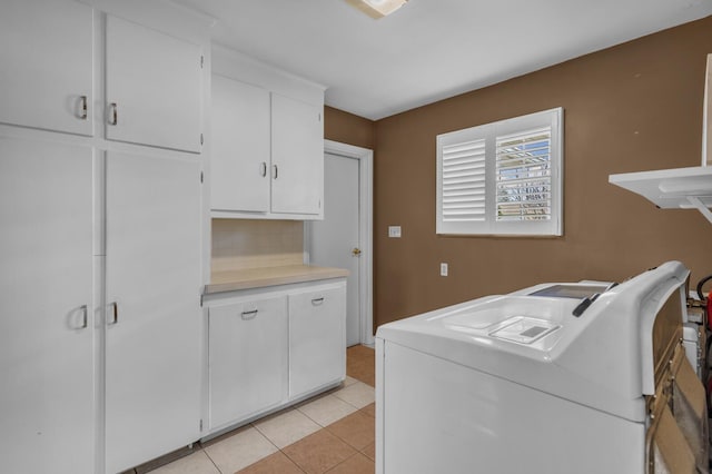 laundry area with light tile patterned floors and cabinet space