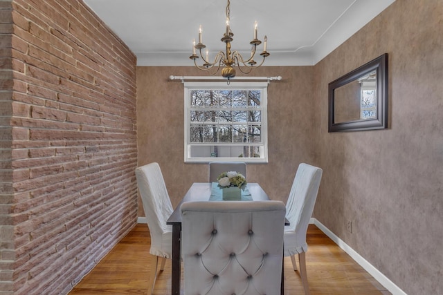 dining room featuring baseboards, a chandelier, and wood finished floors