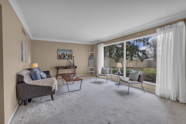 living room with crown molding, visible vents, baseboards, and carpet floors