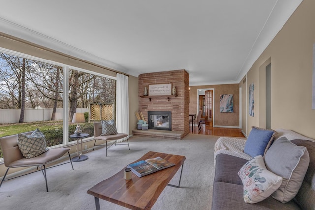 carpeted living room featuring a large fireplace and ornamental molding