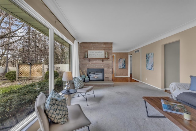 carpeted living area featuring ornamental molding, visible vents, baseboards, and a brick fireplace