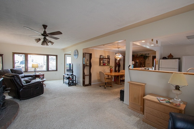 living room featuring a textured ceiling, light colored carpet, baseboards, and a ceiling fan