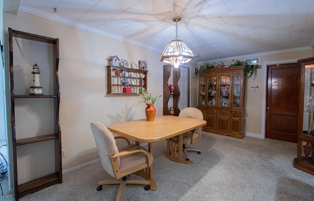 carpeted dining room with a chandelier, visible vents, baseboards, and ornamental molding