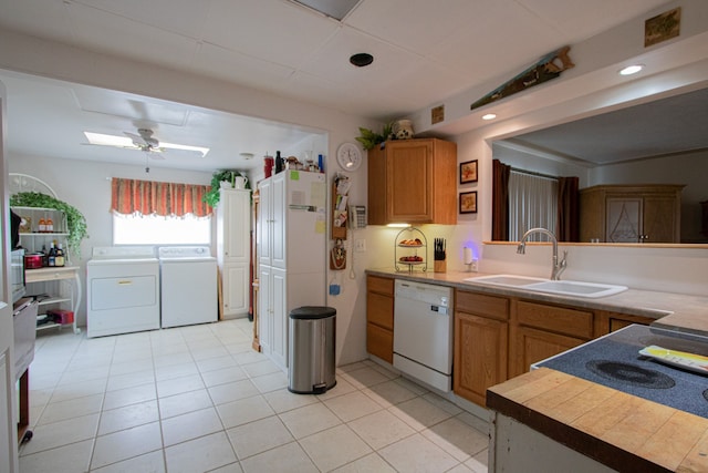 kitchen with separate washer and dryer, white dishwasher, a sink, light countertops, and recessed lighting