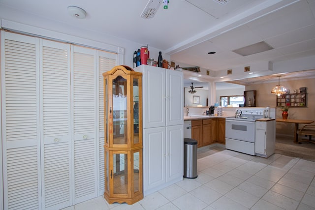 kitchen featuring decorative light fixtures, a sink, white appliances, a peninsula, and light tile patterned flooring
