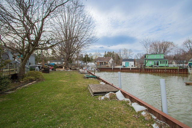 view of dock with a water view and a lawn