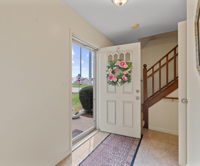 foyer with stairs and baseboards