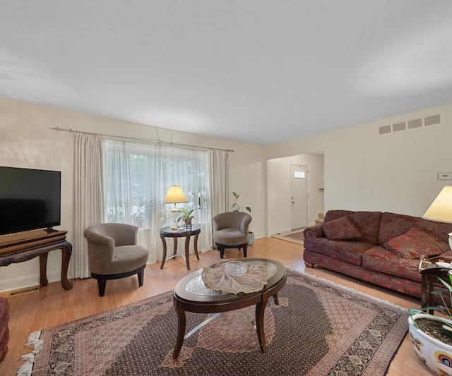living area with light wood-style floors and visible vents