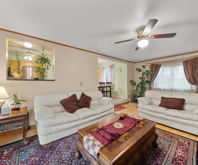 living room with crown molding, wood finished floors, and ceiling fan