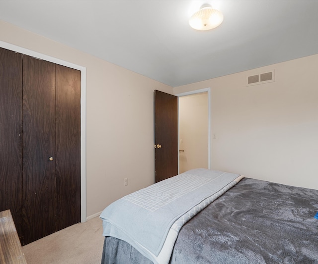 bedroom with carpet, visible vents, and a closet